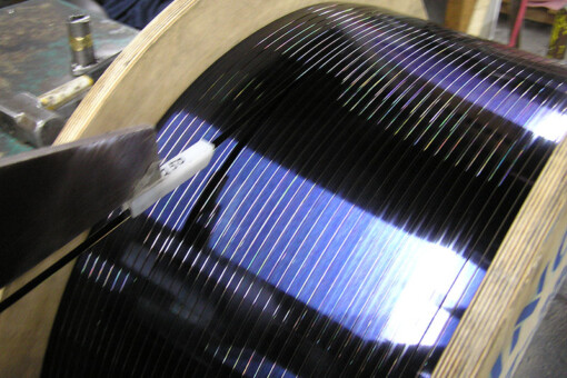 Oscillate-wound tempered spring steel spool